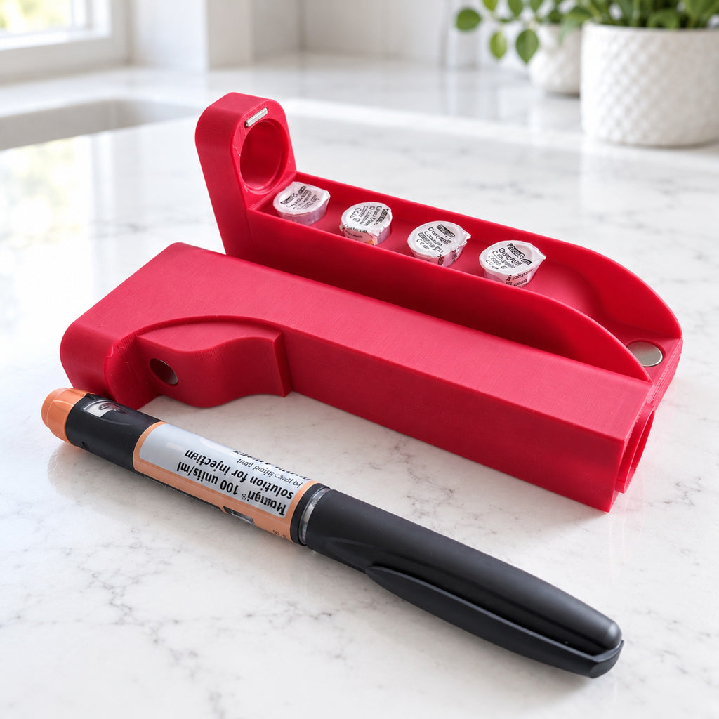Open red PenSafe case with four needle spaces and an example medication pen beside it.