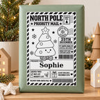 Christmas Tree North Pole sticker personalised with Sophie, shown on a wrapped Christmas gift.